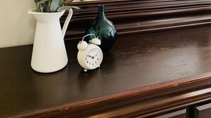 A bedroom with a bed, a nightstand, a white vase with green leaves, a white clock, and a green vase. - Brand New near Houston Medical Center / Rice University / NRG Stadium (Houston)