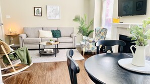 A living room with a sofa, coffee table, chairs, and a dining table. - Brand New near Houston Medical Center / Rice University / NRG Stadium (Houston)