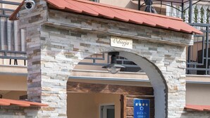 A stone archway leading to a pool area with a sign reading "Odiseja" and another sign indicating "Kuca za odmor". - Villa Odiseja (Tribalj)