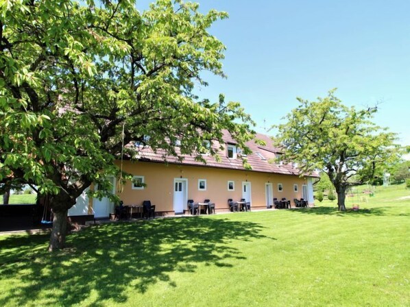 A two-story building with a flat roof and a large lawn in front.