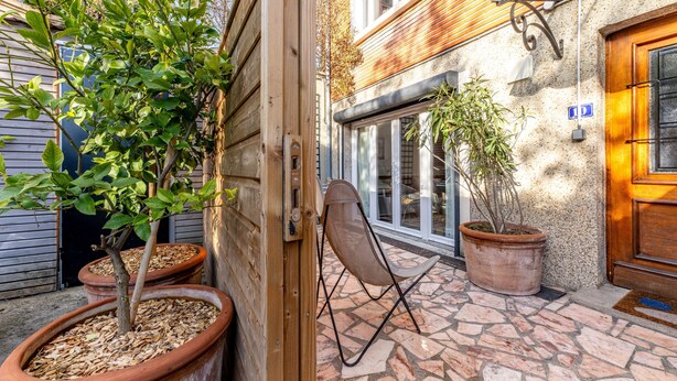 A courtyard with potted plants, a folding chair, and a stone-tiled floor. - Comfortable studio in a quiet location 10 minutes from the RER station (Joinville le pont)