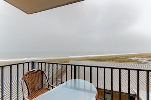Relax on the balcony with a wicker chair and glass table, taking in the stunning ocean views.