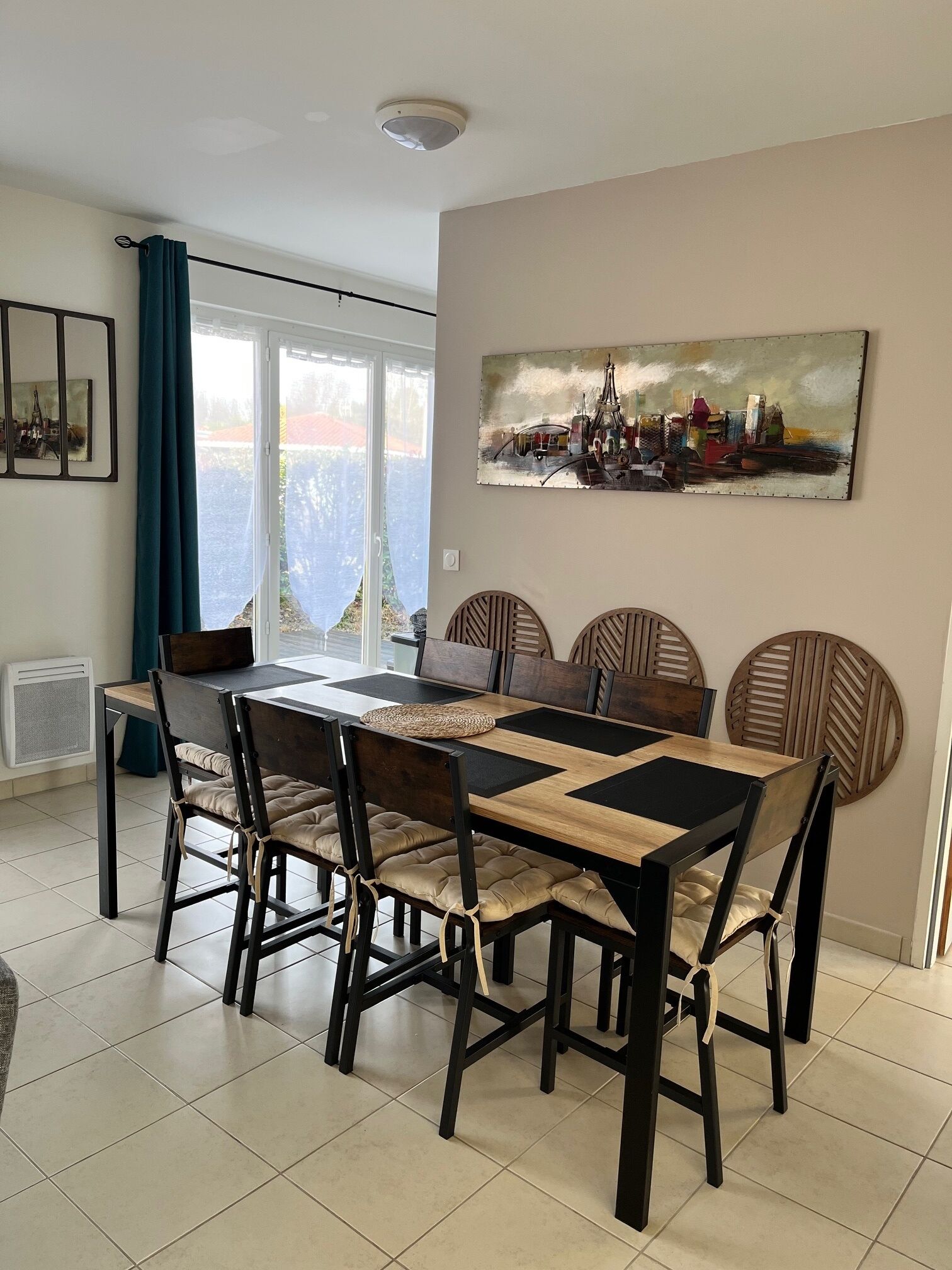 A dining area with a table set for six, surrounded by chairs with cushioned seats.