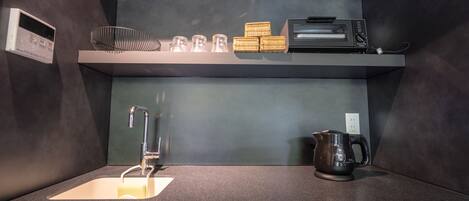 A modern kitchen with a built-in microwave, a coffee maker, and a toaster on the countertop.