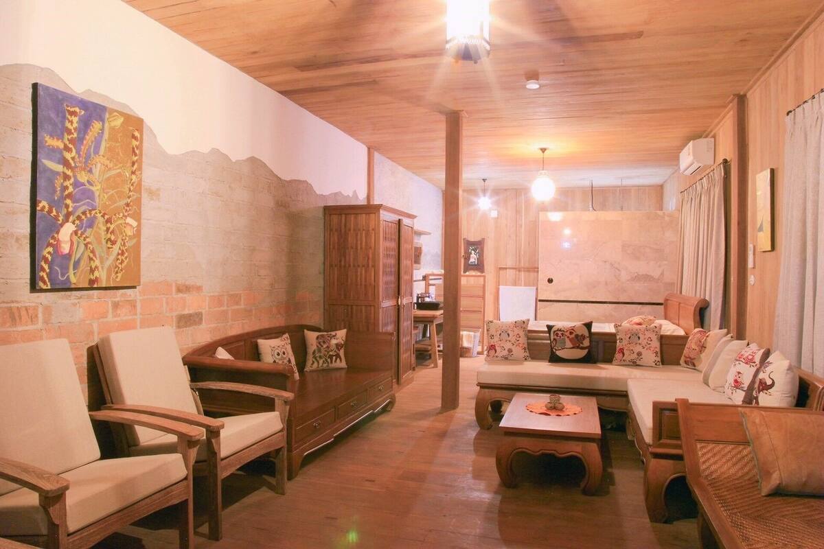 Un interior acogedor y rústico con muebles de madera, una pared de ladrillo y un techo con vigas a la vista.
