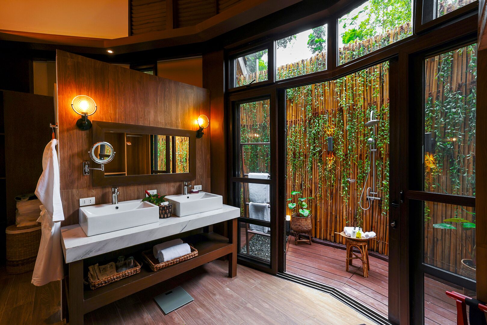 A modern bathroom with two sinks, a large mirror, and a wooden vanity.