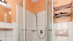 Ein Badezimmer mit Dusche, Toilette, Waschbecken und Handtuchhalter.