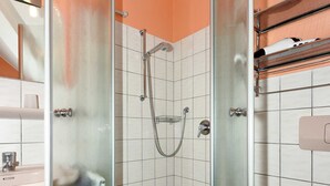 Une salle de bain avec une douche à parois de verre, une baignoire et des toilettes.