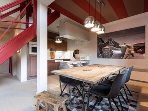 Eine moderne Küche mit Essbereich, einem Holztisch und Stühlen.