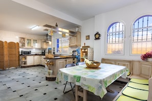 A kitchen with a dining table, chairs, and a window with a view.