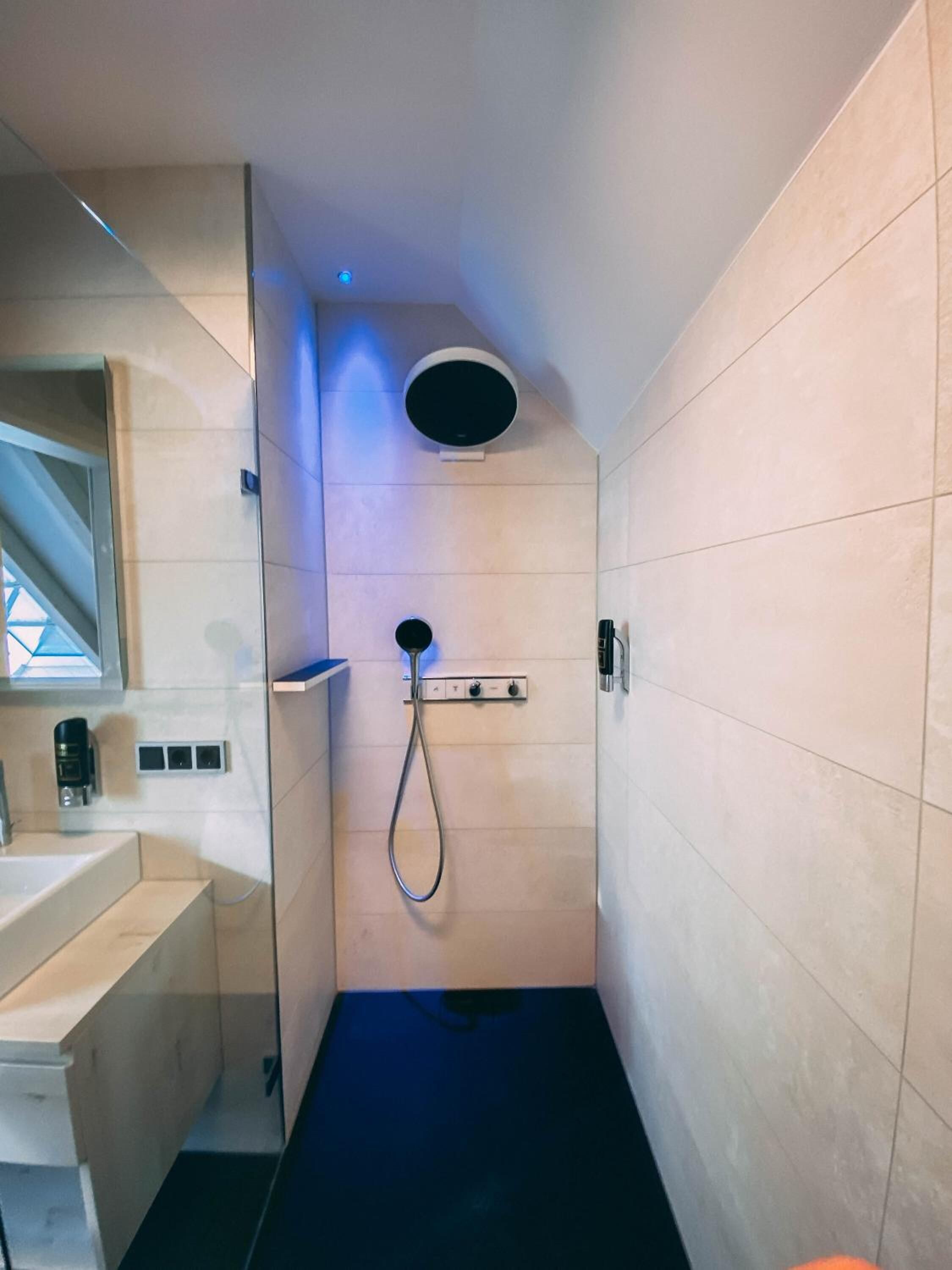 A modern bathroom with a shower, a toilet, and a sink.