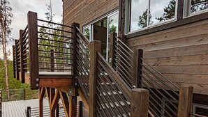 Una escalera de madera con barandillas de metal que da a una terraza.