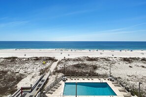 Zona de piscina con vista a la playa y al océano.