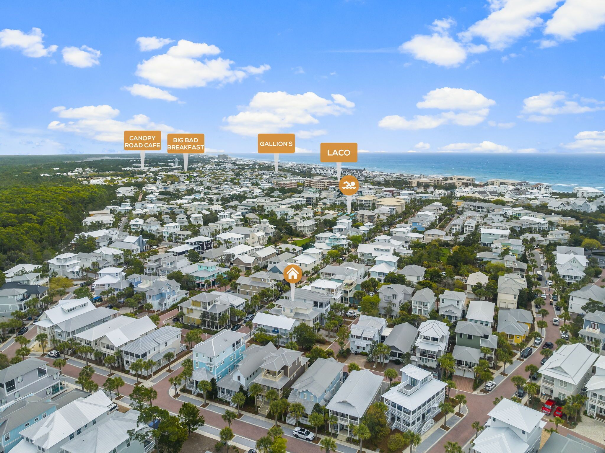 Vista aérea de una zona residencial costera con casas, calles y una playa.