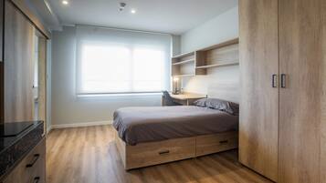 Edredón, escritorio y espacio para trabajar con laptop