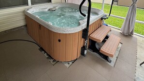 A hot tub in a covered outdoor area with a view of a house and a grassy yard. - Hot Tub House Escape – 3BR in The Villages at Special Rates (The Villages)