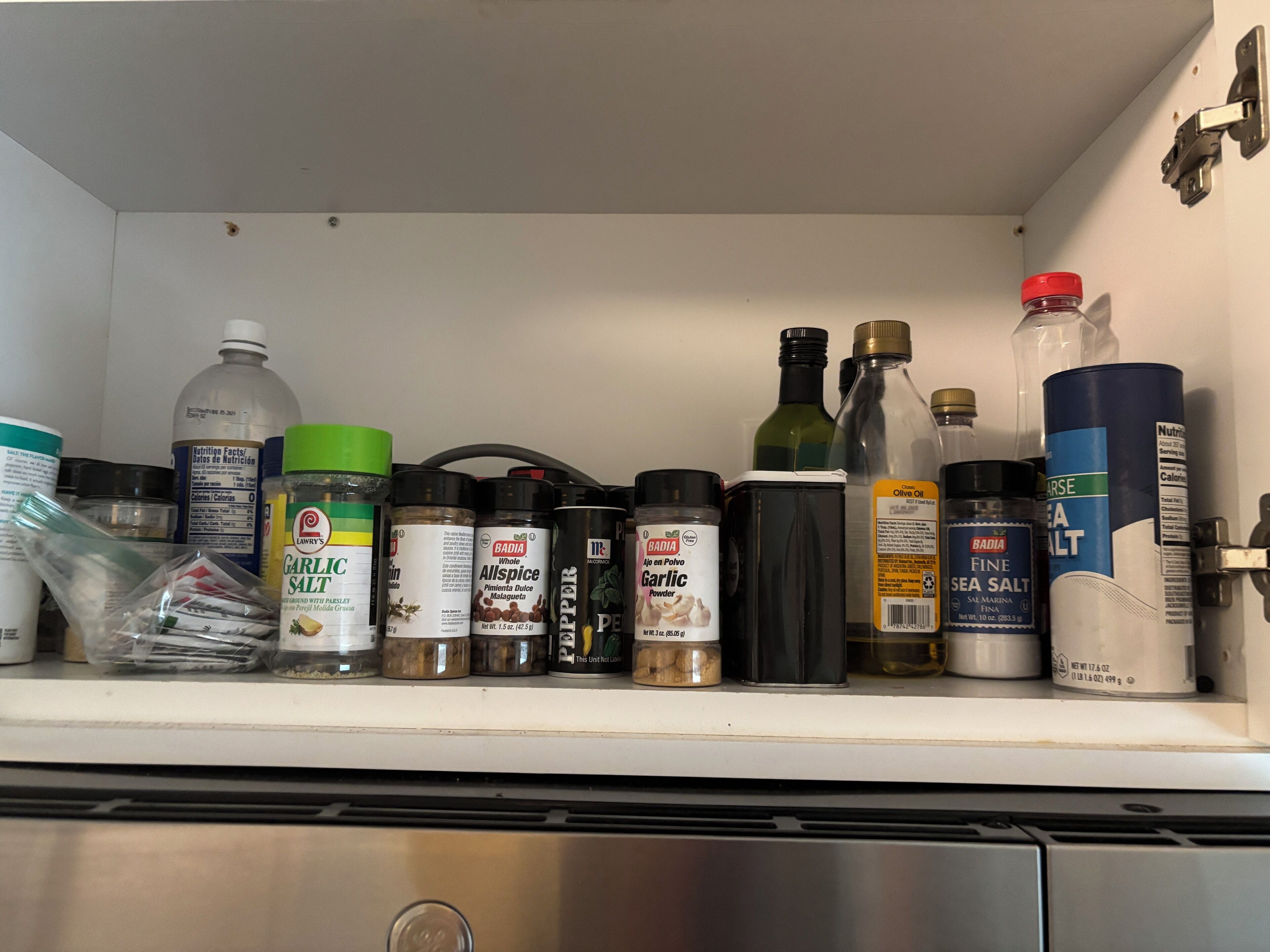 Una estantería en la cocina con diversas especias y condimentos.