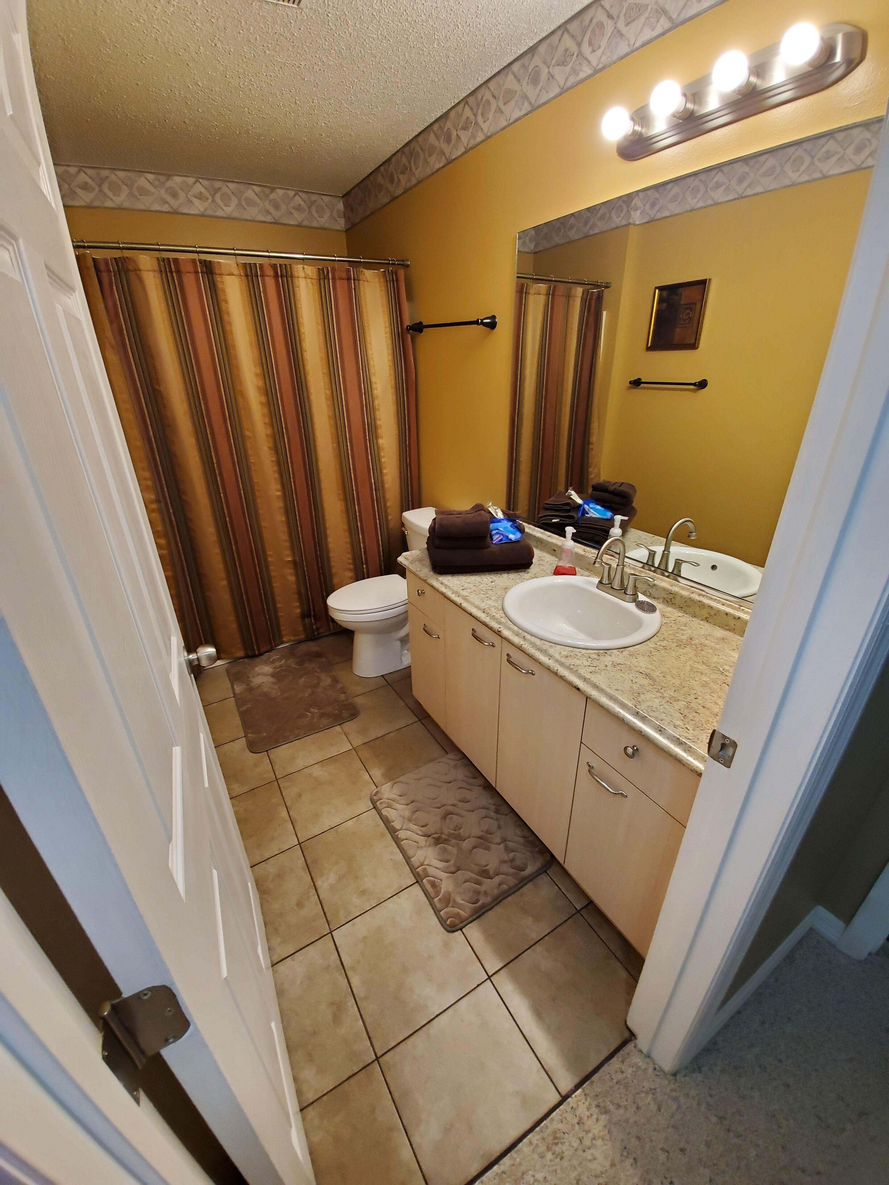 Une salle de bain avec des toilettes, un lavabo et un miroir.