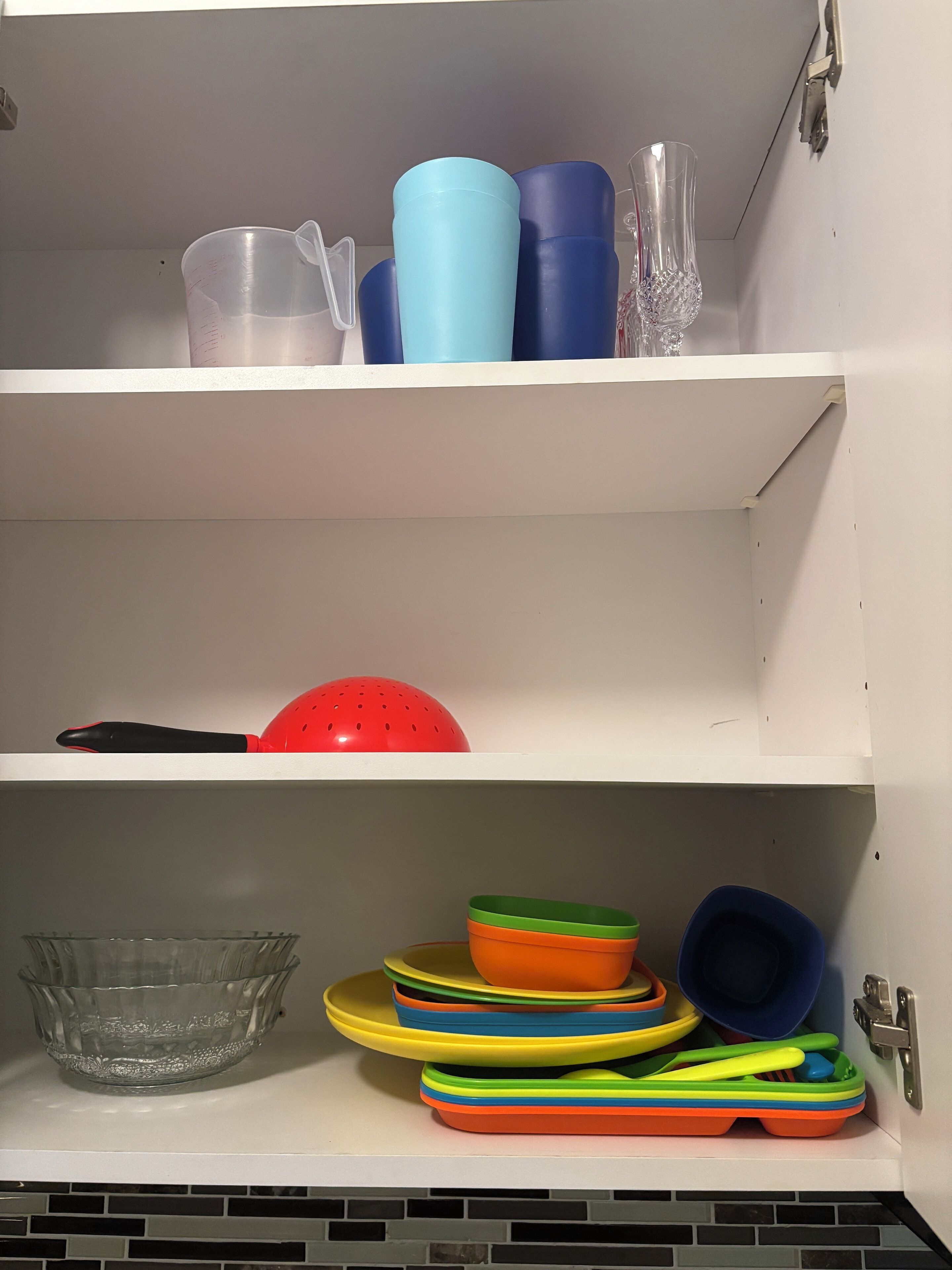 A kitchen cabinet with various kitchenware items.