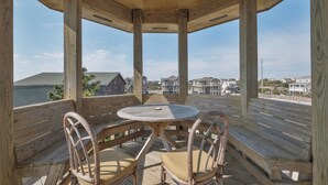 Eine Holzterrasse mit einem runden Tisch und zwei Stühlen mit Blick auf eine Wohngegend.