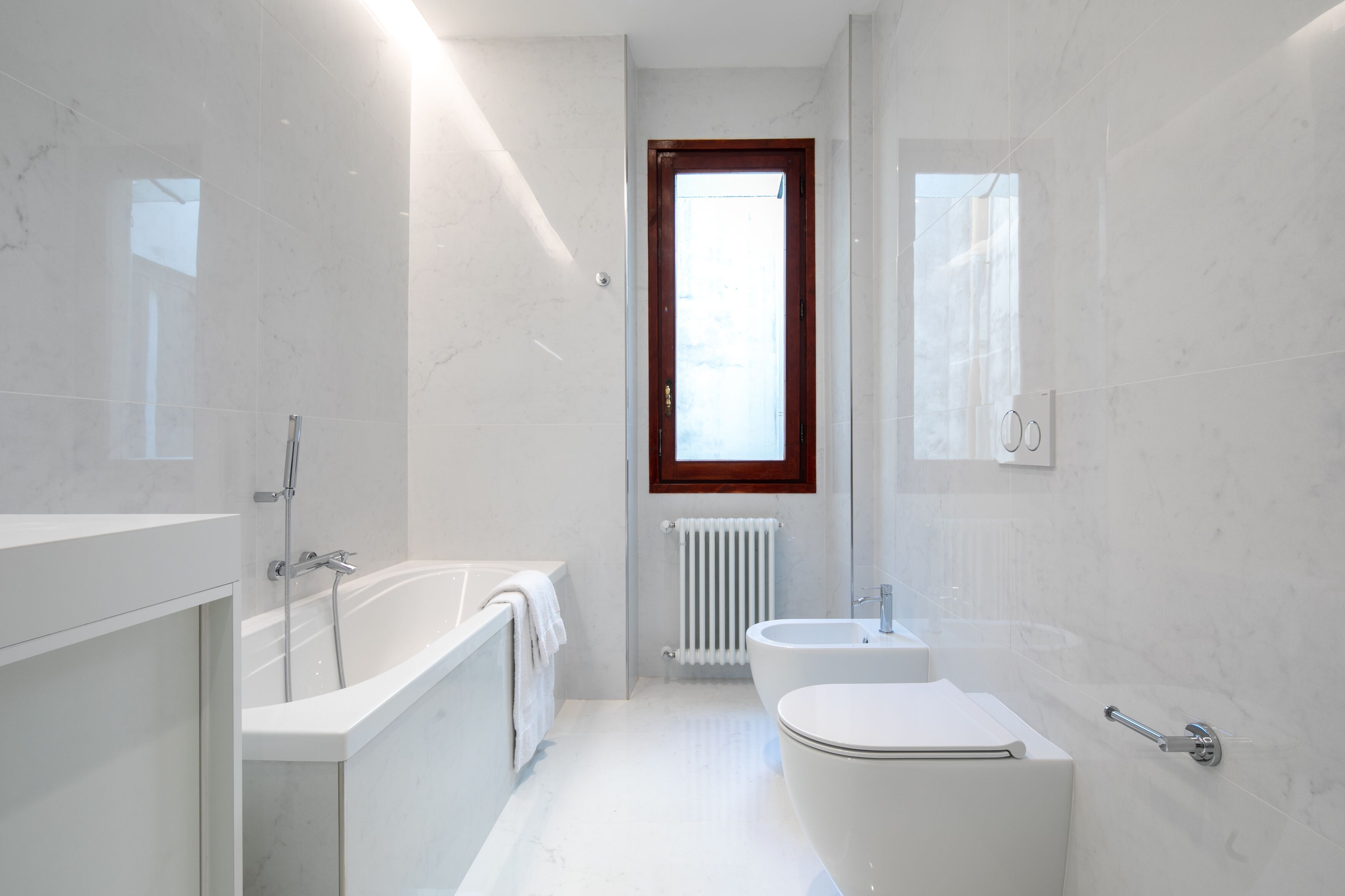 A modern bathroom with a bathtub, toilet, and sink.