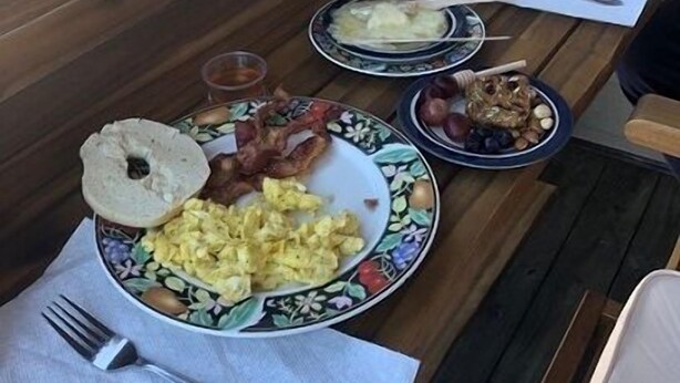 En träbänk med ett bord dukat för frukost.