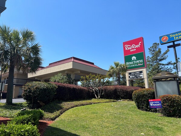 Ein Schild von RedCoop Inn mit der Aufschrift Home To Own Studio, Red Roof und einem Schild des Gerichts Judge Ashley Wright Superior Court.