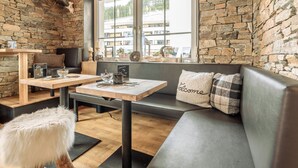 Ein gemütlicher Sitzbereich mit Steinwand, Holztisch und Bank.