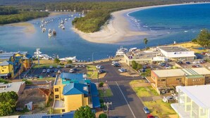 A coastal town with a marina, buildings, and a road. - Ishtar Apartment 8 by Book Jervis Bay - Luxury Studio (Huskisson)