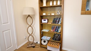 Una estantería con libros, objetos decorativos y un pequeño juego de ajedrez.