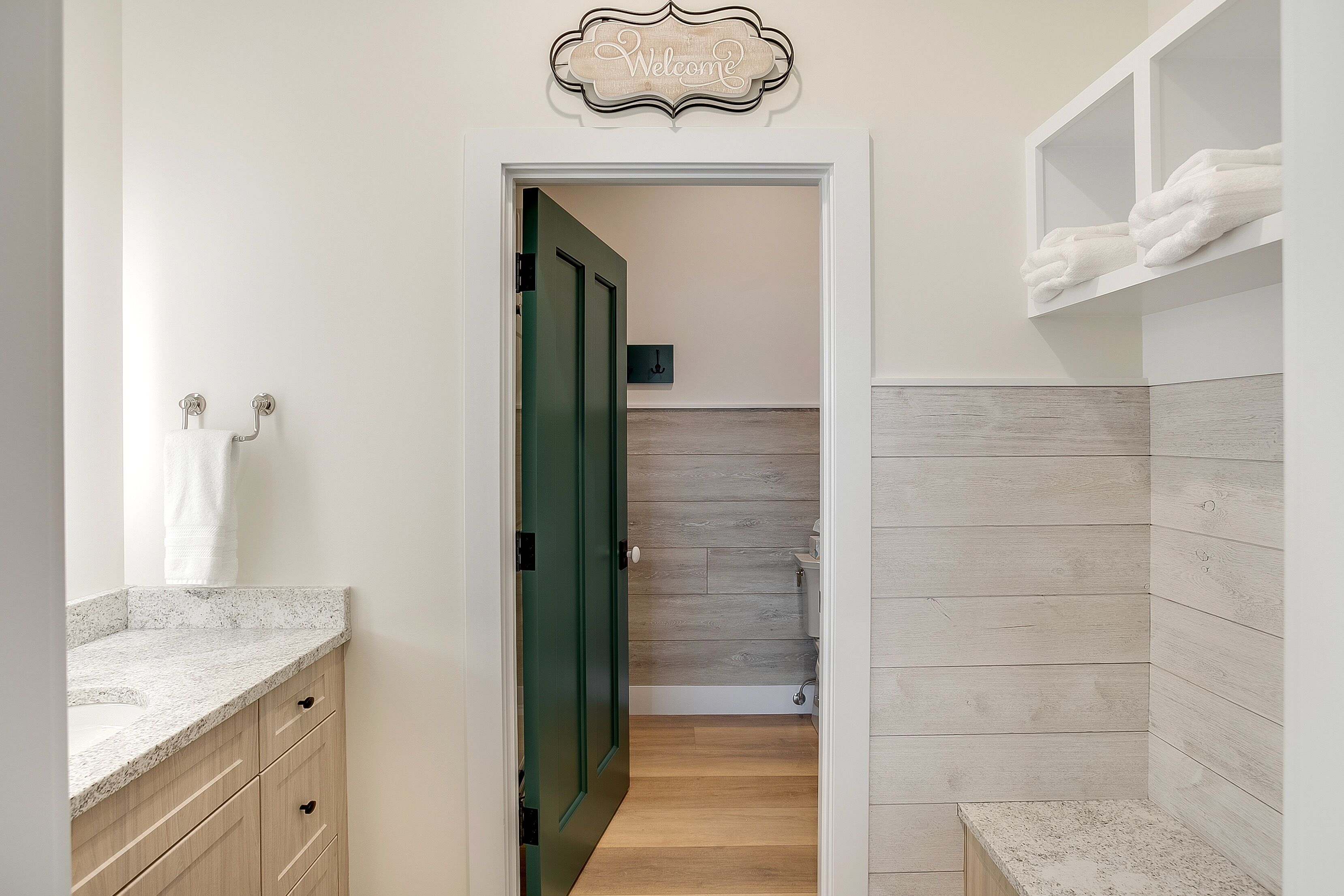 A modern bathroom with a wooden vanity, a toilet, and a shower area.