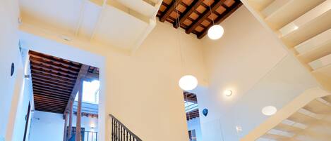 A staircase with a wooden ceiling and a black balustrade.