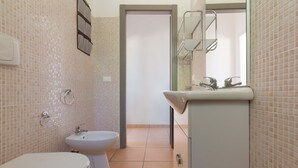 Un baño con inodoro, bidé y lavamanos.