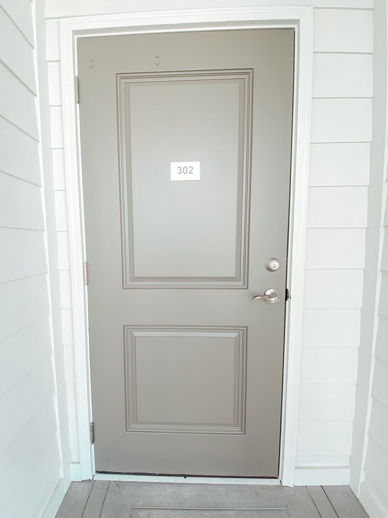 A closed door with a number plate '302' and a keyhole.