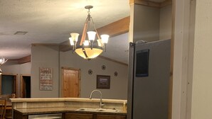 A kitchen with wooden cabinets, a stainless steel refrigerator, and a built-in dishwasher. - Entire House - Relax and Ride at Grace Ranch (Victoria)