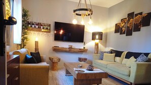 Ett modernt vardagsrum med ett soffbord i trä, en soffa, en tv som är monterad på väggen och en världskarta som konstverk.