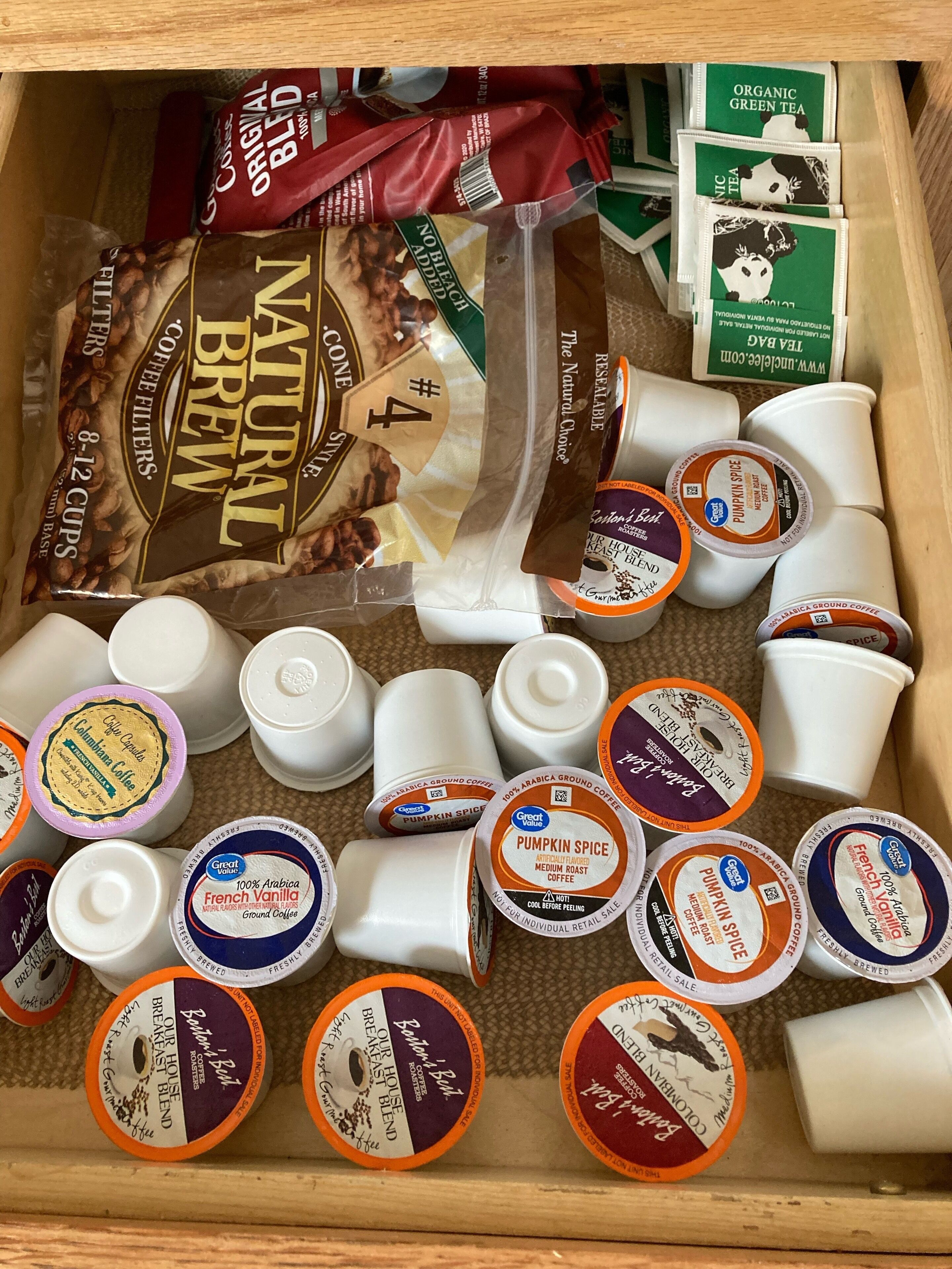 Verschiedene Kaffeeprodukte, darunter Kaffeepäckchen und Kapseln, in einer Schublade.