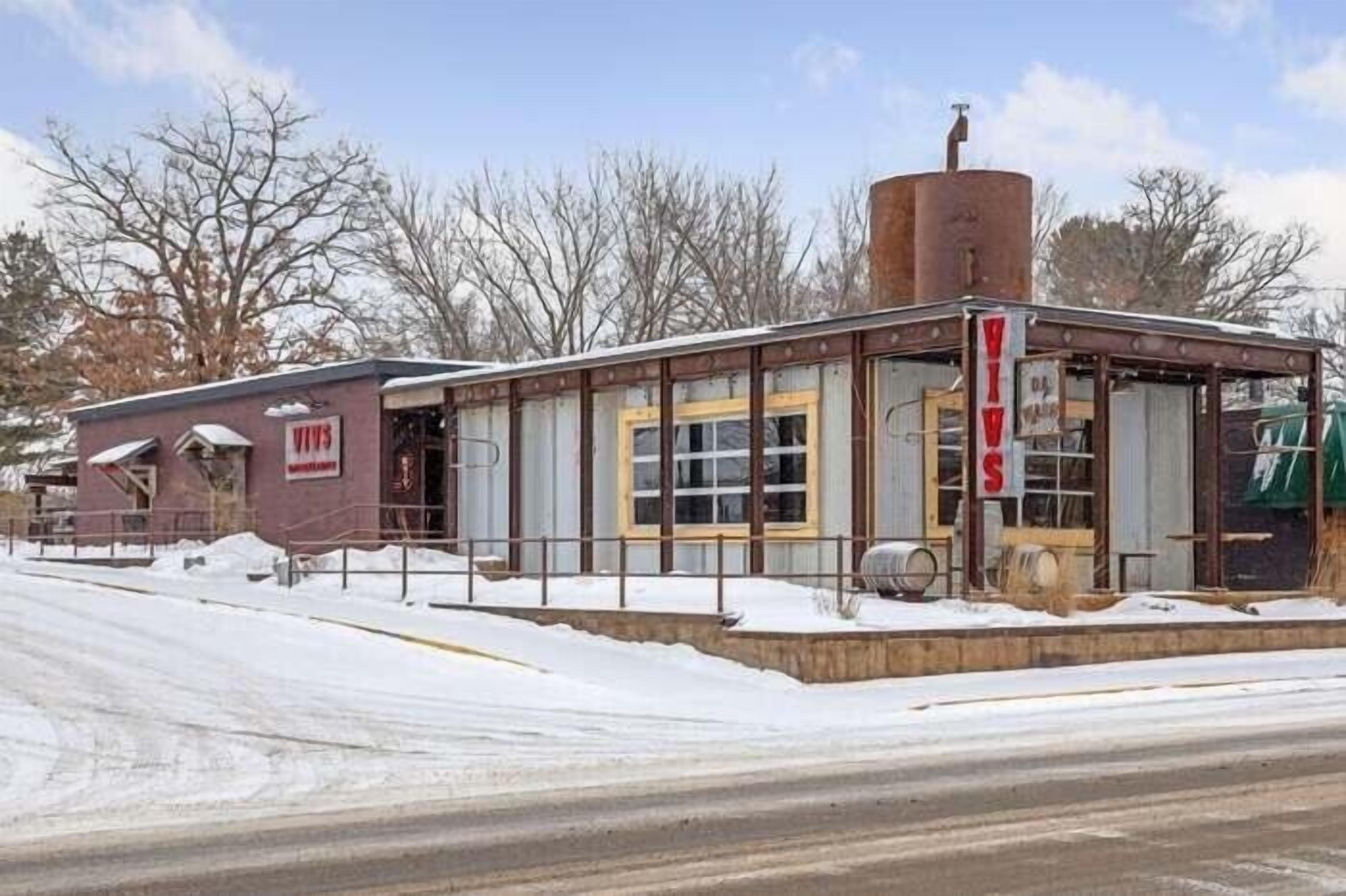 A small, single-story building with a metal exterior and a large cylindrical tank on the roof.