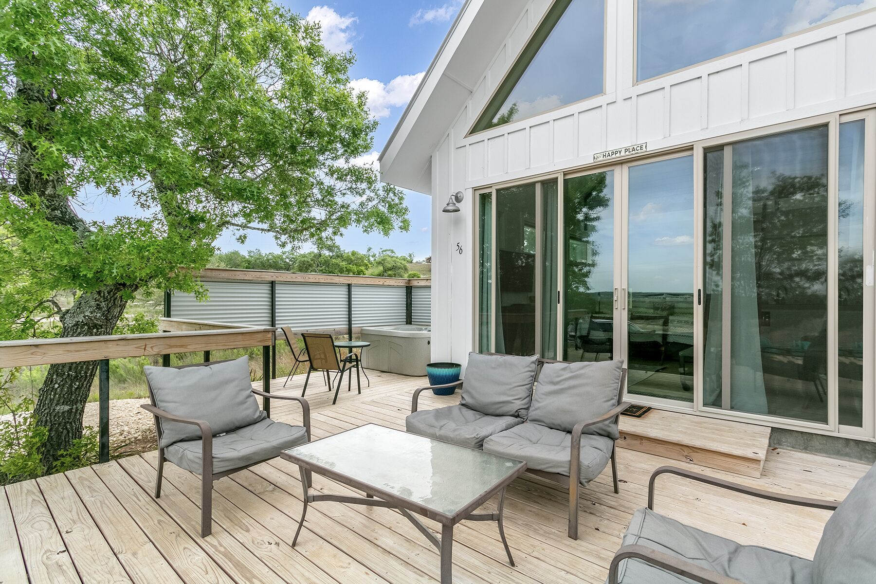 Une terrasse dotée de mobilier d’extérieur, d’une porte vitrée et offrant une vue sur les environs.