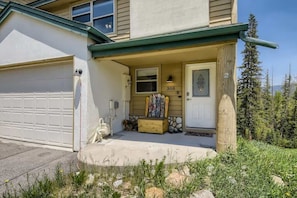 A two-story house with a garage, a front door, and a mailbox.