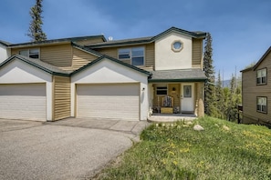 A two-story house with a garage, a front porch, and a small garden. - 4BR Townhome w/ Private Hot Tub, Garage, and Deck (Silverthorne)