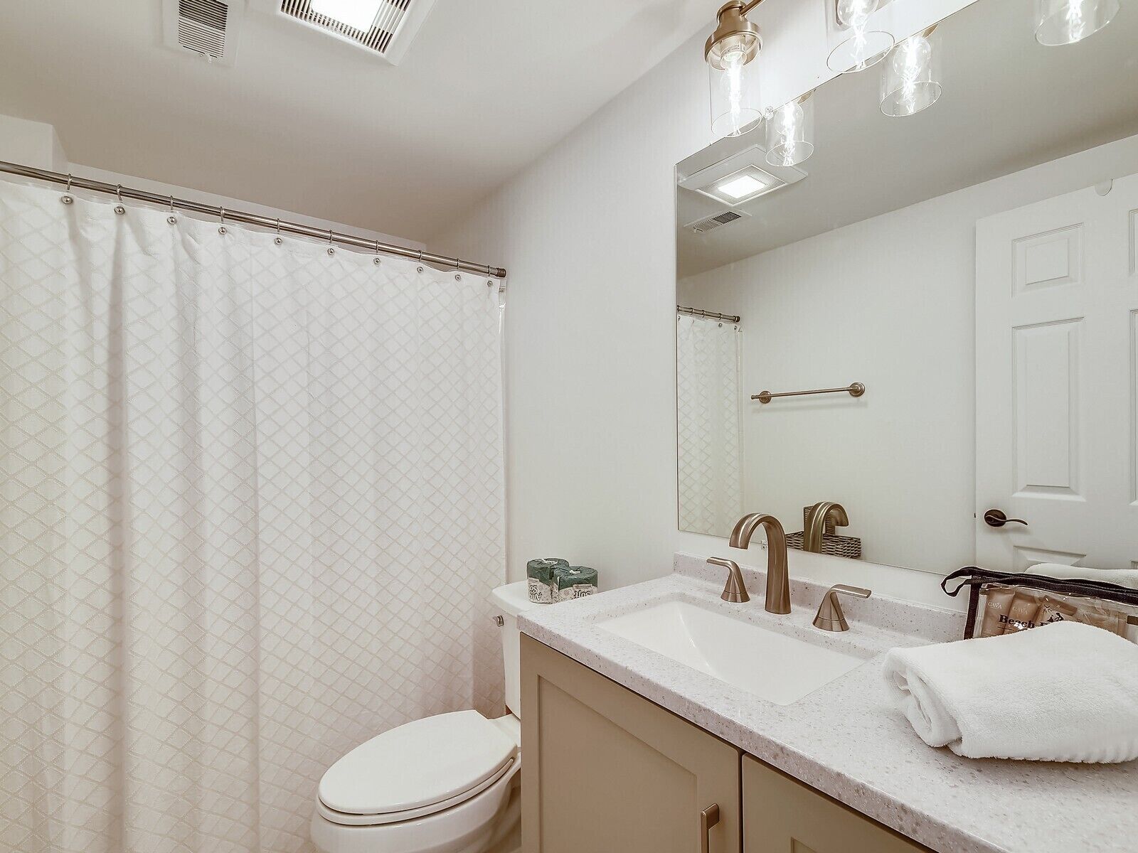 Un baño con inodoro, lavamanos y espejo.