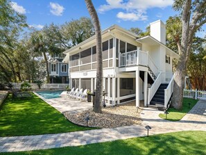 A two-story house with a balcony, a pool, and a well-maintained lawn. - 2nd Row Beach Home w/ a Short Walk to Restaurants (Hilton Head Island)