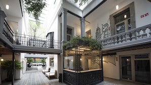Un vaste atrium comprenant un espace d’accueil central, un escalier et un balcon doté d’une balustrade.