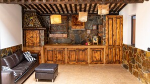 Un salon chaleureux avec une cheminée en pierre, des meubles en bois et un canapé en cuir.