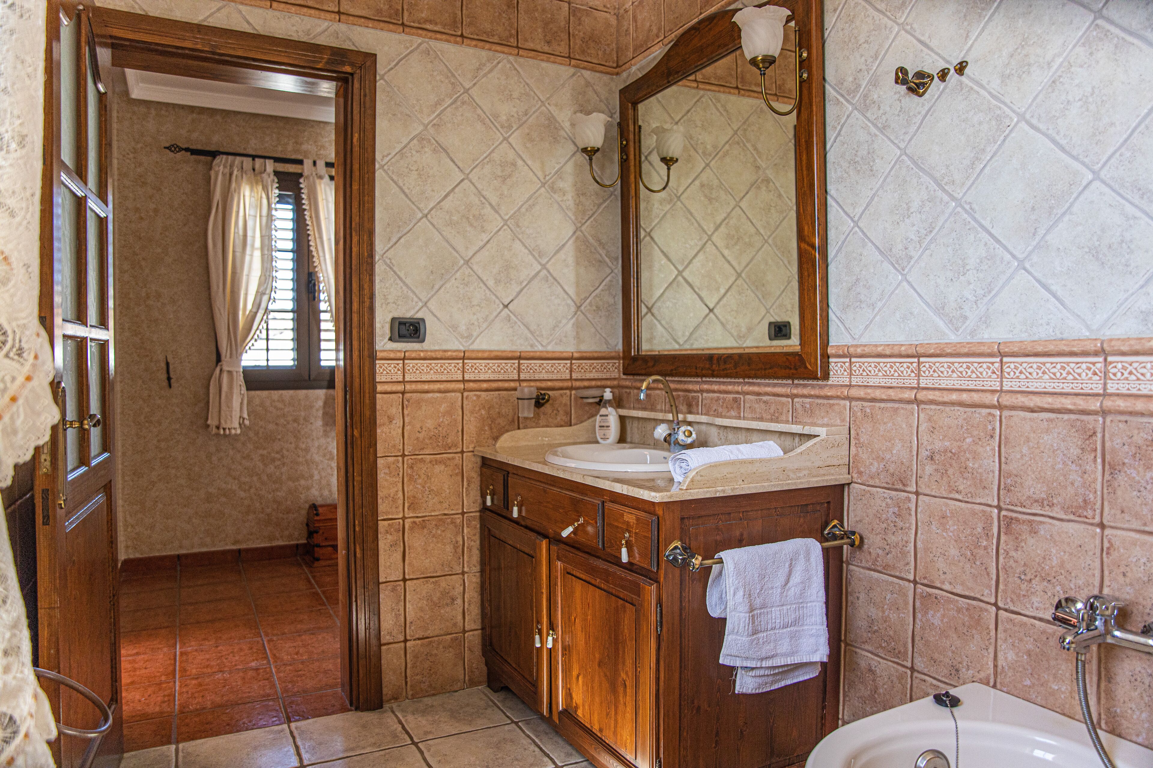 Ein Badezimmer mit einem Holzlager, einem Waschbecken, einem Spiegel und einer Badewanne.