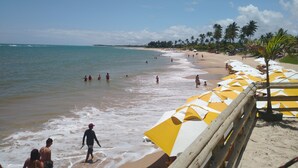 Una playa con sombrillas y palmeras.