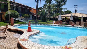 Una piscina con borde de azulejos, rodeada por un patio de ladrillo.