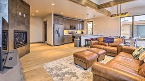 A modern kitchen with stainless steel appliances, a dining area with leather sofas, and a large window providing a view of the outside. - Relax Fireside: Silverthorne Home 11 Mi to Skiing! (Silverthorne)
