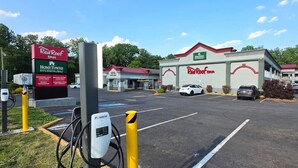 Een Red Roof Inn met een parkeerplaats, een tankstation en een Home Towne Studios bord.